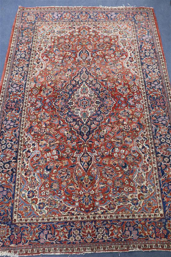 A Middle Eastern red and blue ground rug, 216cm x 139cm